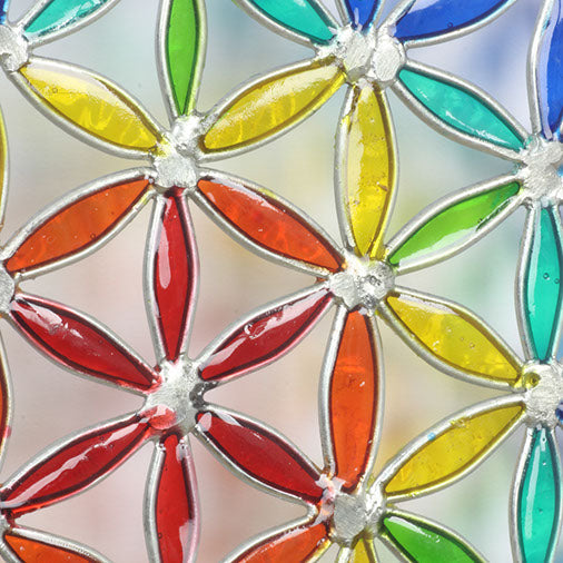 Round Flower of Life suncatcher with an overlapping-circle pattern in full rainbow resin, bordered by a deep blue ring