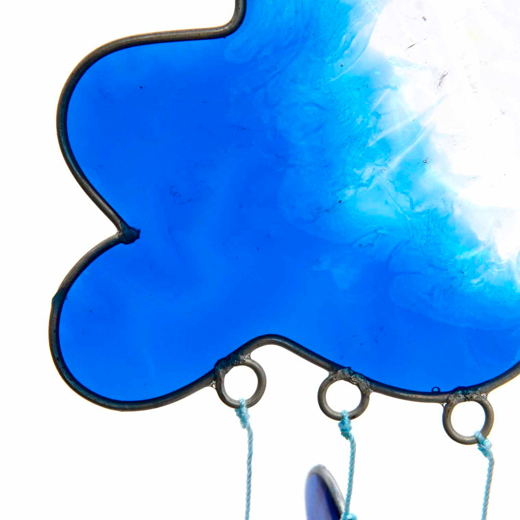 Blue resin cloud suncatcher with six threads of rainbow hearts dangling beneath in jewel tones of red, orange, yellow, green, blue and purple