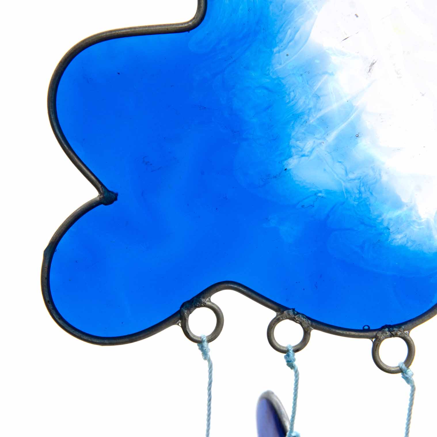 Blue resin cloud suncatcher with six threads of rainbow hearts dangling beneath in jewel tones of red, orange, yellow, green, blue and purple