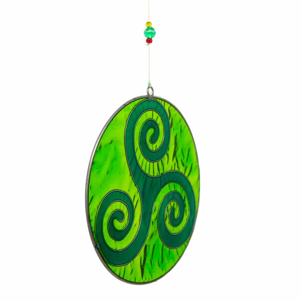 Round deep-green suncatcher with a Celtic triskele of three interlocking spirals, in a soldered metal frame
