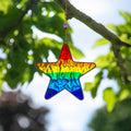 Small star-shaped suncatcher with a bright rainbow stripe running across it, in a soldered metal frame