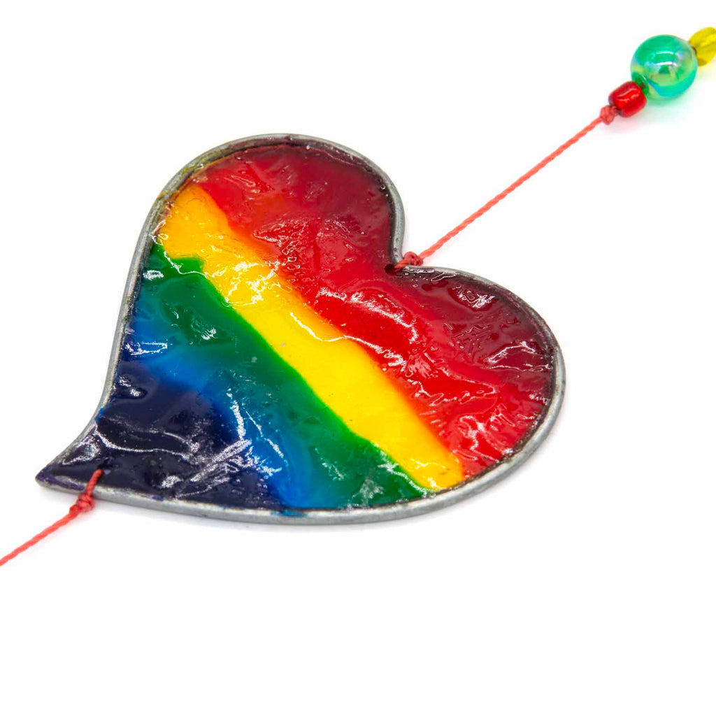 Vertical string of six rainbow-striped heart suncatchers in stained-glass effect resin, each with a small arrow detail at the top