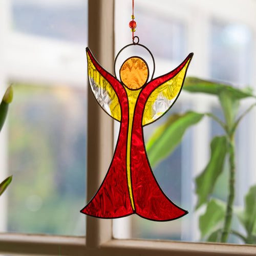 Angel-shaped suncatcher in warm red and amber resin with outstretched wings rising to a halo, in a soldered metal frame
