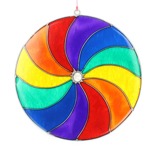 Round suncatcher with bold rainbow segments curving from the centre in a spinning pinwheel pattern, in a soldered metal frame