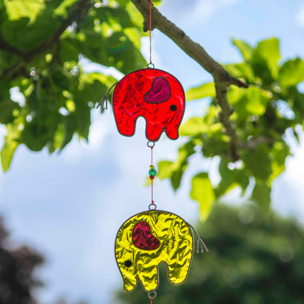 Vertical string of five jewel-tone elephant suncatchers in red, yellow, green, blue and purple, in soldered metal frames