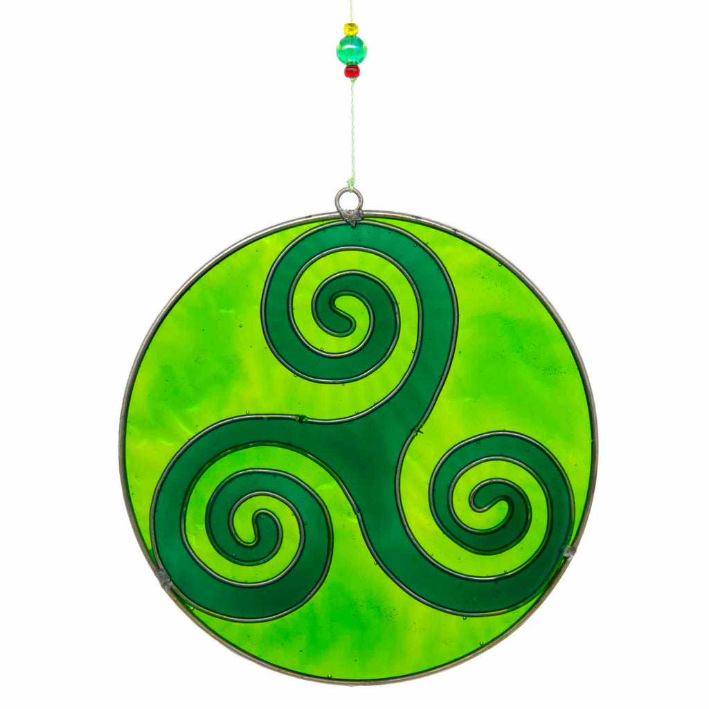 Round deep-green suncatcher with a Celtic triskele of three interlocking spirals, in a soldered metal frame