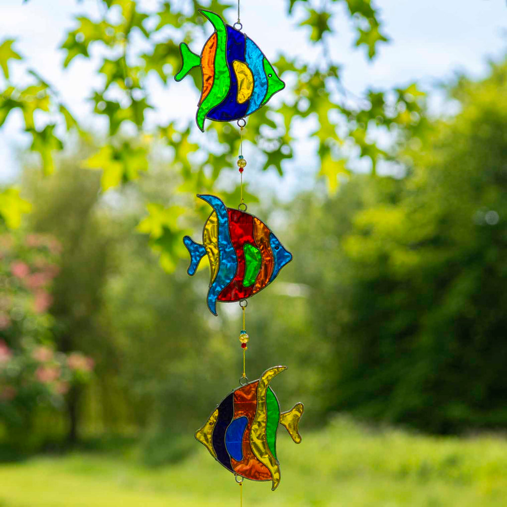 Vertical string of three angel fish suncatchers in bright turquoise, cobalt, lime and ruby, in soldered metal frames