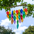 Hanging windchime of rainbow-coloured shell leaves strung from a length of bamboo