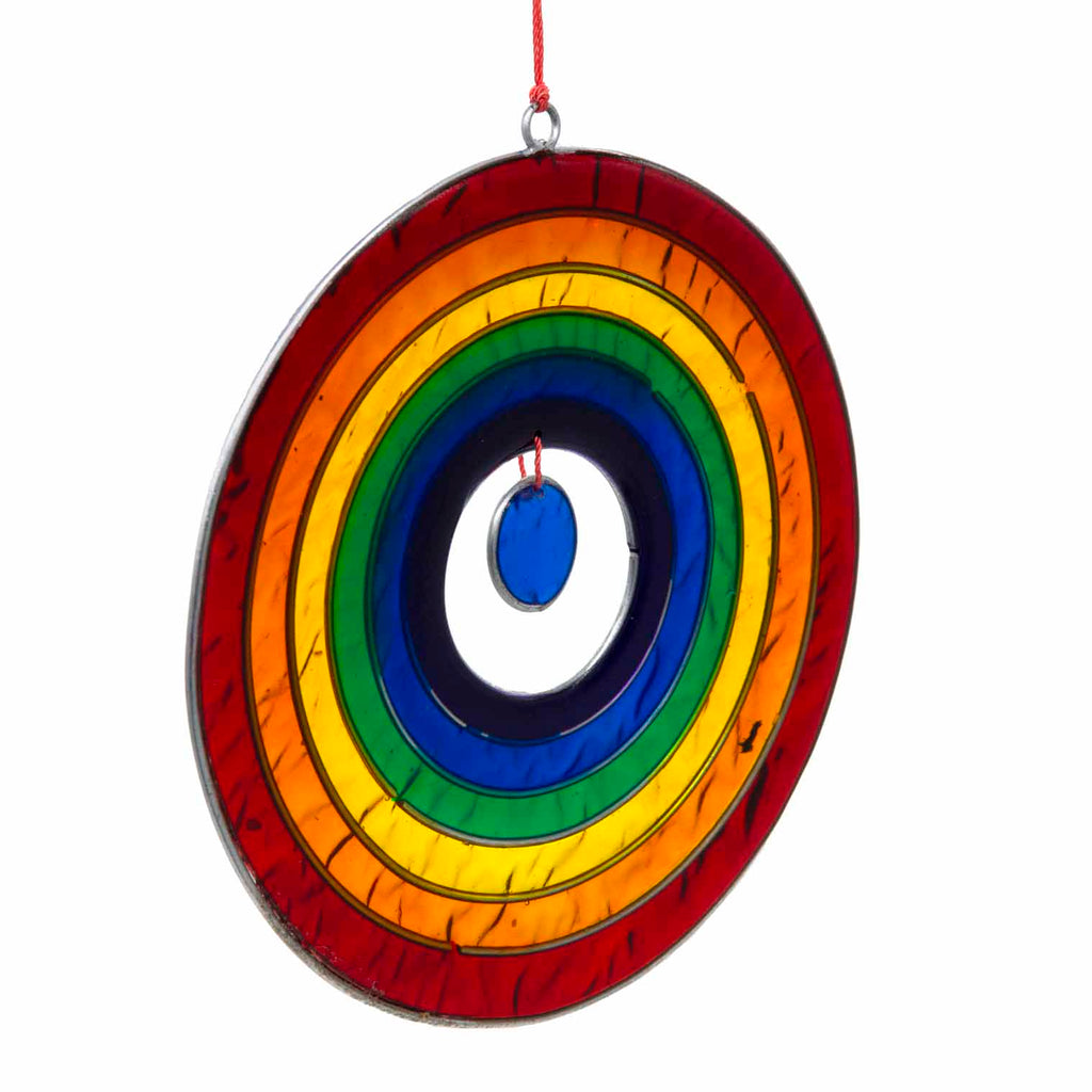Round suncatcher with concentric rings of rainbow colour radiating from a deep blue centre, in a soldered metal frame
