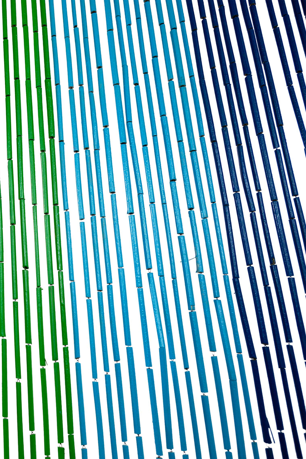 Hand-painted bamboo bead curtain with bright horizontal rainbow stripes, hanging in a doorway