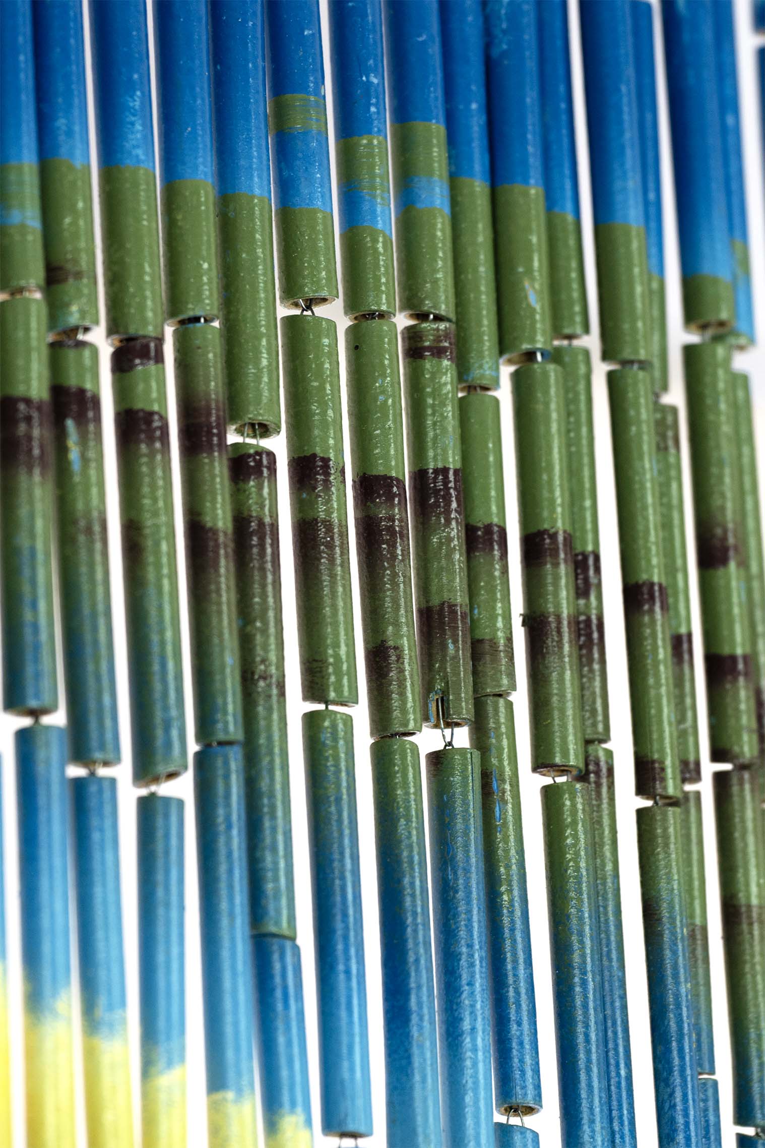 Hand-painted bamboo bead curtain showing a tropical sunset with palm tree silhouettes, hanging in a doorway